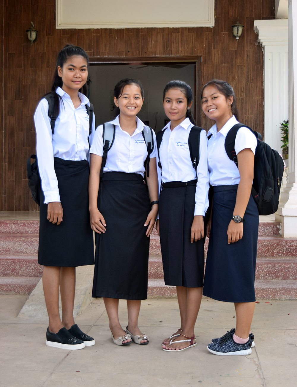from left, Sopha, Sreydao, Chamnan, and Som smile in front of the girls dormitory